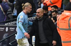 El delantero noruego del Manchester City, Erling Haaland (izquierda), es felicitado por el técnico español del Manchester City, Pep Guardiola, cuando abandona el campo durante el partido de fútbol de la Premier League inglesa entre el Manchester City y el Wolverhampton Wanderers en el Etihad Stadium de Manchester, al noroeste de Inglaterra, el 22 de enero. , 2023. (Foto de Paul ELLIS / AFP) / RESTRINGIDO A USO EDITORIAL. No se utiliza con audio, video, datos, listas de dispositivos, logotipos de clubes/ligas o servicios 'en vivo' no autorizados. Uso en línea durante el partido limitado a 120 imágenes. Se pueden usar 40 imágenes adicionales en tiempo extra. Sin emulación de vídeo. El uso de las redes sociales durante el partido está limitado a 120 imágenes.