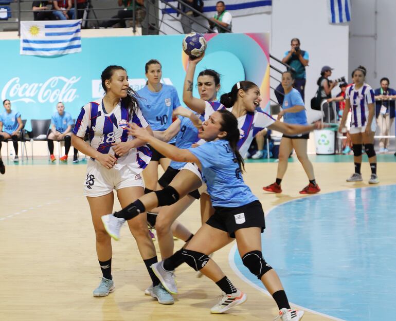 La jugadora paraguaya Delyne Leiva intenta un disparo ante la fuerte marca de las defensoras de Uruguay. Las Guerreras se impusieron 29-21 a la celeste y buscarán un lugar en el podio del hándbol.
