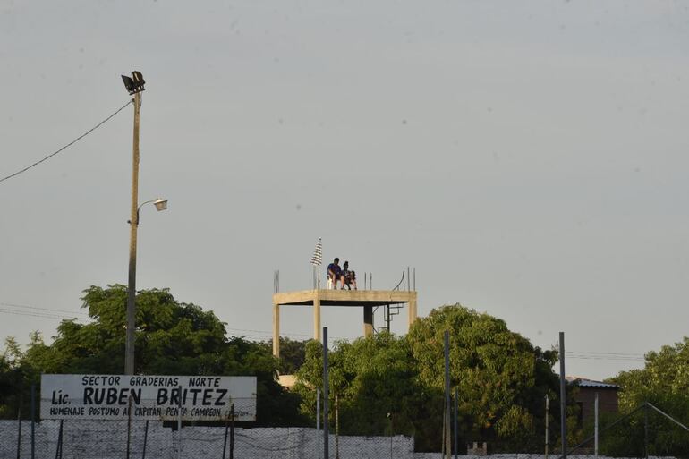 Un hincha de Cerro Porteño y del 12 de Octubre en la parte más alta de una obra siguiendo el partido.
