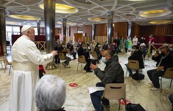 Una imagen proporcionada por Vatican Media muestra al Papa Francisco yendo al atrio del Aula Pablo VI para visitar a personas en condiciones de necesidad, mientras esperaban ser vacunadas contra el Covid-19.