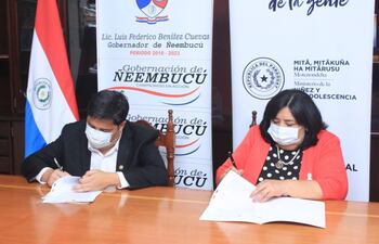 El gobernador Luis Benítez, y la ministra de la Niñez y Adolescencia Teresa Martínez, firman el documento de cooperación interinstitucional.