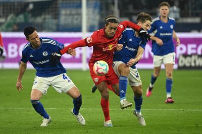El danés Yussuf Poulsen (c), del Leipzig, intenta abrirse paso ante el japonés Maya Yoshida (L) y el suizo  Cedric Brunner, defensores del Schalke 04.