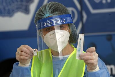 Una enfermera rumana muestra a un conductor la vacuna y la jeringa de Pfizer que le aplicará, en un centro de vacunación de Bucarest.