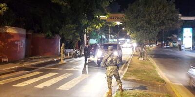 Efectivos militares y policiales verificando a los ocupantes de una camioneta en la vía pública.