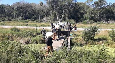 Agentes de la Senad extraen los panes de cocaína hallados en el campamento de Puerto Pinasco, tras el operativo del sábado último.