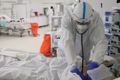 Un trabajador sanitario asiste a un enfermo de covid internado en un hospital.