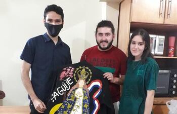 Ariel Escurra, integrante de Tierra Adentro, recibe la chaqueta pintada a mano por la joven artista Milagros Martínez Peralta.