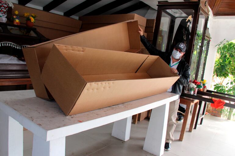 El director de Cementerios de la Alcaldía de Santa Cruz, Ronald Romero, muestra un ataúd de cartón.