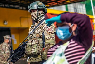 Un soldado acompaña a personal del Ministerio de Salud peruano durante la realización de tests de COVID-19 en un mercado en Lima.