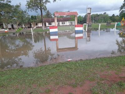 La entrada principal de la Escuela y Colegio Luciano Zacarías de Ñurundiay inundada por el taponamiento del drenaje de la ruta.