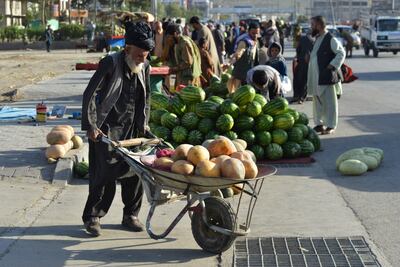 Un vendedor transporta melones en un mercado en Kabul, Afganistán.