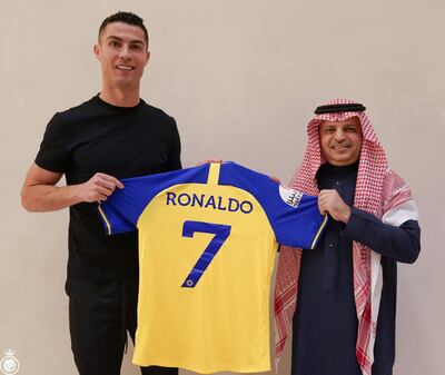 Cristiano Ronaldo posando con la casaca número 7 del Al Nassr junto a un dirigente del club saudí.
