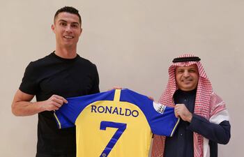 Cristiano Ronaldo posando con la casaca número 7 del Al Nassr junto a un dirigente del club saudí.
