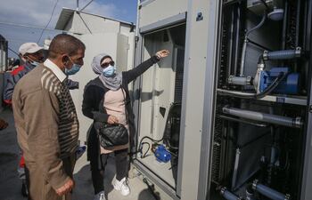 La ingeniera palestina Nadia Tubail verifica un generador de agua que funciona a energía solar y que extrae agua potable del aire.