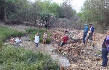 Pobladores de María Auxiliadora, entre ellos varios niños proceden a limpiar y canalizar el tajamar, para utilizar la poca agua que aún queda en dicho reservorio, aunque esta sea sucia, no tienen otra opción, ya que los camiones cisternas que acarrean agua lo hacen de manera esporádica.