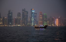 Un dhow, tradicional embarcación de madera, navega por la noche en la bahía de Doha, la capital catarí.