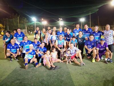 El trofeo de campeón en manos del presidente José González, en medio de la celebración de los integrantes de NSA.