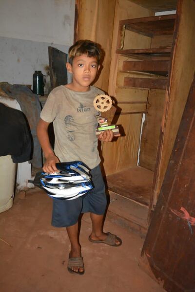 Ramón Mancuello muestra orgulloso su trofeo de campeón y el casco que le regalaron.