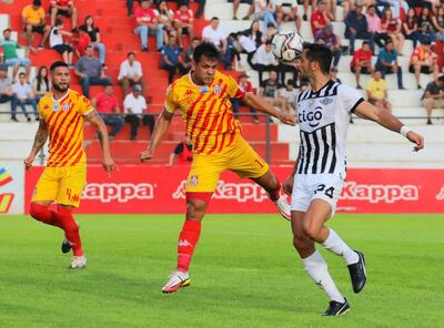 El capitán de General Caballero, José Vera, no deja progresar en su intento de hacerse de la pelota a Roque Santa Cruz.
