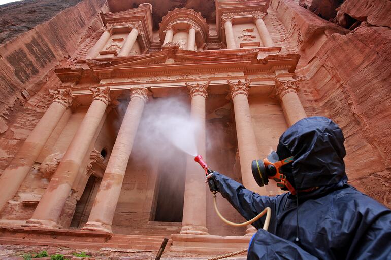 Un voluntario realiza tareas de desinfección en el sitio arqueológico de la antigua ciudad de Petra, en Jordania.