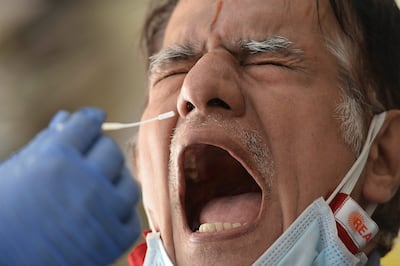 Un hombre se prepara para que le tomen una muestra para el test del Covid-19.