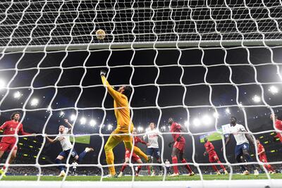 Liverpool's Brazilian goalkeeper Alisson Becker makes a save during the English Premier League football match between Tottenham Hotspur and Liverpool at Tottenham Hotspur Stadium in London, on December 19, 2021. (Photo by JUSTIN TALLIS / AFP) / RESTRICTED TO EDITORIAL USE. No use with unauthorized audio, video, data, fixture lists, club/league logos or 'live' services. Online in-match use limited to 120 images. An additional 40 images may be used in extra time. No video emulation. Social media in-match use limited to 120 images. An additional 40 images may be used in extra time. No use in betting publications, games or single club/league/player publications. /