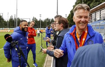 Memphis Depay (i) y el entrenador Louis van Gaal (R), hablando con la prensa antes de la práctica de ayer de la selección de Holanda.