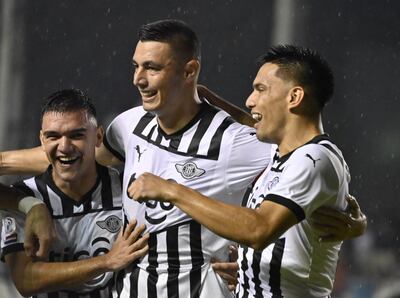 Diego Gómez (d), celebrando el gol de campeonato junto a Lucas Sanabria (i) y Óscar Cardozo (c).