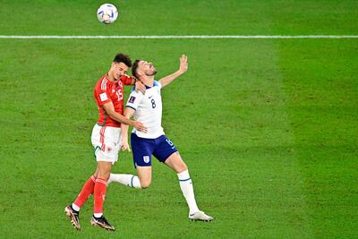 Ethan Ampadu, de Gales, trata de despejar el balón ante la llegada del ingles Jordan Henderson