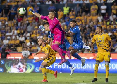 Nahuel Guzmán, arquero de Tigres, rechaza el balón ante la presencia de los paraguayos Carlos González (i), de Tigres, y Juan Escobar, de Cruz Azul.