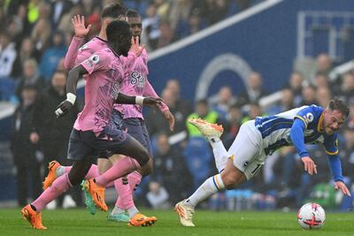 El argentino Alexis Mac Allister tropieza y va al suelo ante la presencia de tres jugadores del Everton durante el partido que Brighton perdió ayer de local por 5-1.