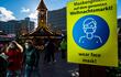 Un cartel pidiendo a las personas usar mascarilla, en la entrada de un mercado navideño en Berlín, Alemania.