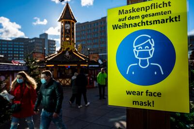 Un cartel pidiendo a las personas usar mascarilla, en la entrada de un mercado navideño en Berlín, Alemania.