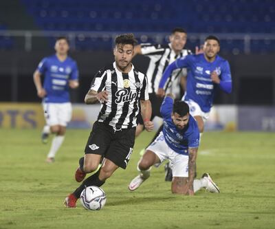 El solense Gabriel Báez pierde el equilibrio en su intento por frenar el avance de Héctor “Tito” Villalba. Fue el tercer empate consecutivo de Libertad en el torneo.