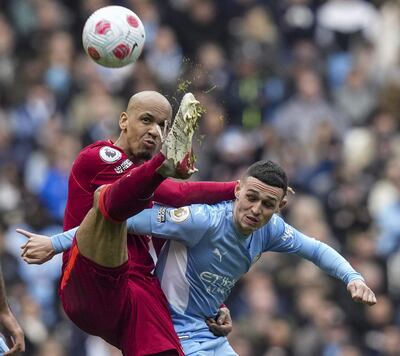 El brasileño Fabinho, del Liverpool, puntea el balón ante el inglés Phil Foden, de Manchester City.
