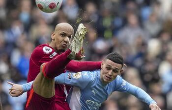 El brasileño Fabinho, del Liverpool, puntea el balón ante el inglés Phil Foden, de Manchester City.