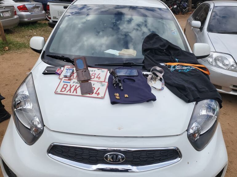 El auto Kia Pincanto blanco incautado, junto con las evidencias recogidas por los uniformados. 