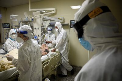 Un paciente con Covid internado en una unidad de terapia intensiva recibe asistencia médica.