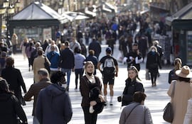 Varias personas pasean por la Rambla de Barcelona. La OMS redujo los días de cuarentena de contactos cercanos de enfermos covid.