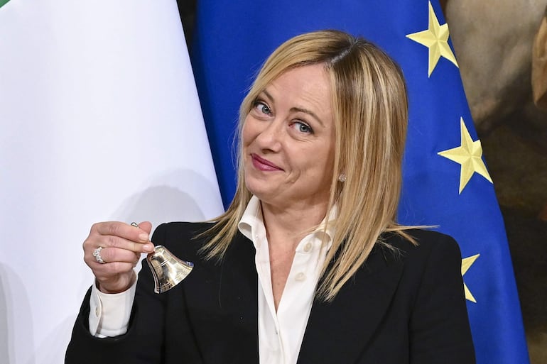 La primera ministra de Italia, Giorgia Meloni, posa con la campana utilizada por el presidente del gabinete para gestionar los debates del gabinete, durante la ceremonia de entrega en el Palacio Chigi en Roma, Italia, el 23 de octubre de 2022. (EFE)/ETTORE FERRARI