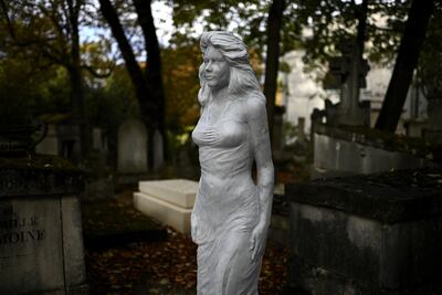 Un estatua a escala humana de una mujer sin identificar adorna una tumba vacía en el cementerio de Pere Lachaise en París.