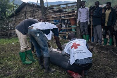 Voluntarios de la Cruz Roja envuelven cuerpos en mantas en una zona de inundaciones en Nyamukubi, República Democrática del Congo.
