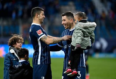 El costarricense Cristian Gamboa (i) y el brasileño Danilo Soares, jugadores del Bochum, celebran con sus respectivos hijos la histórica victoria lograda ayer ante el poderoso Bayern Munich.
