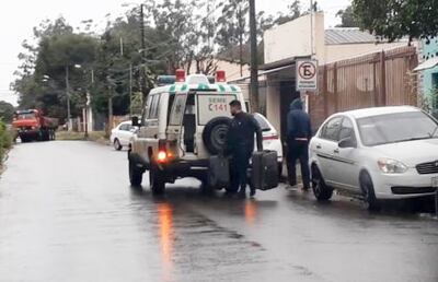 Momento en que el chofer del móvil alza  dos maletas de la vivienda alquilada por el administrador del centro asistencial.