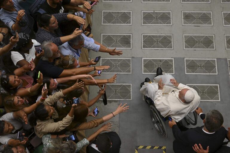 La multitud saluda al papa Francisco en una sala del Vaticano.
