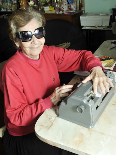 Stela Goiburú, primera docente invidente en una foto de archivo con una máquina de escribir en Braille.