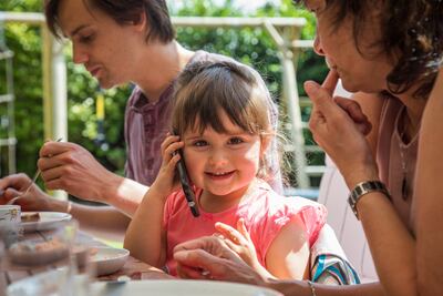 Una niña habla con el teléfono celular de sus padres.
