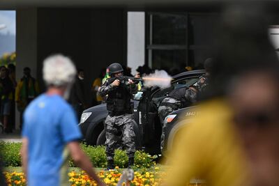 Un policía dispara durante un enfrentamiento con partidarios del expresidente brasileño Jair Bolsonaro en el Palacio de Planalto, en Brasilia, este domingo.