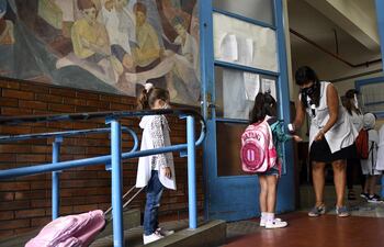 Alumnas de un colegio de Buenos Aires hace fila para que se les tome la temperatura antes de entrar a clases.