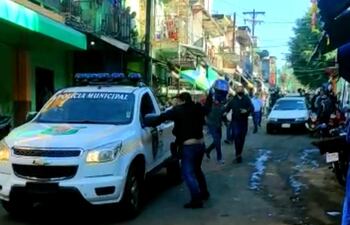 Un comerciante del mercado de abasto arremete con su casco contra la patrullera de la PMT.